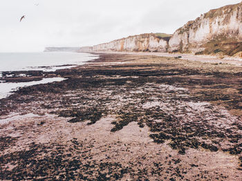 Rock formations on beach against sky