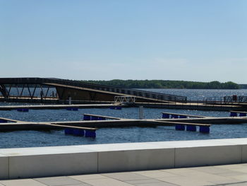 Bridge over river against clear blue sky