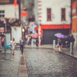 Low section of people walking on wet street