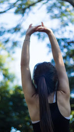 Rear view of woman with arms raised