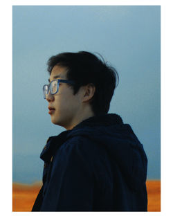 Portrait of man looking away against blue sky