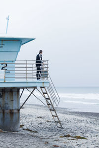 Man standing by sea against sky