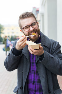 Portrait of young man using smart phone in winter