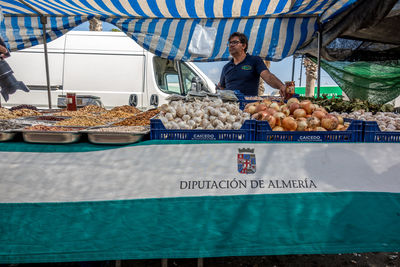Full length of man eating food at market stall