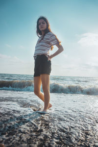 Full length of young woman standing on beach