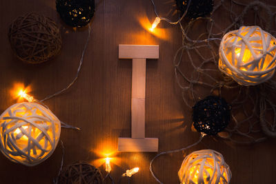 Directly above shot of letter i blocks and illuminated lights on wooden table