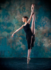 Full length of teenage girl dancing against white background