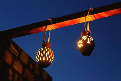 Low angle view of illuminated light against blue sky