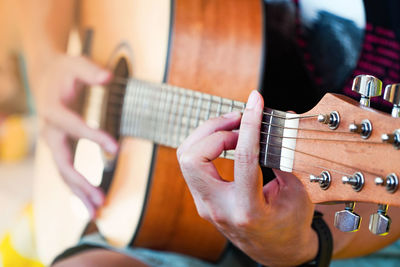 Midsection of man playing guitar