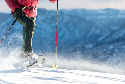 Low section of person on snowcapped mountain during winter