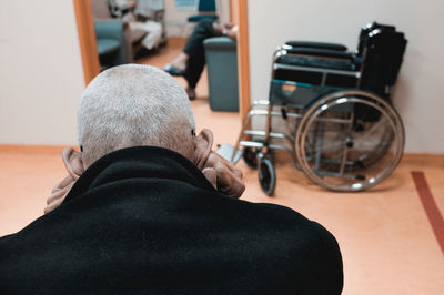 Rear view of man sitting on seat