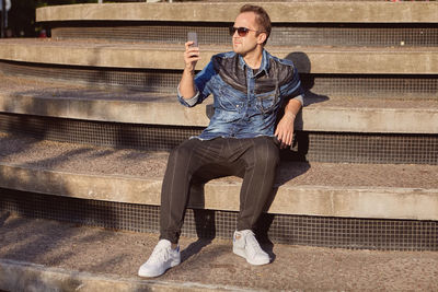 Portrait of young man sitting on bench