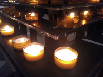 Illuminated tea light candles in temple