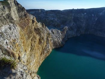 Scenic view of rocky mountains by sea