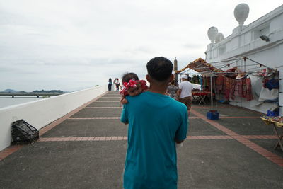 Rear view of man photographing against sky