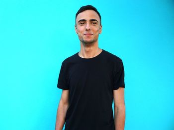 Portrait of young man standing blue background