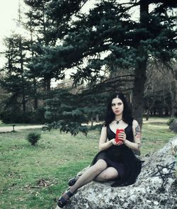 Portrait of young woman sitting on field