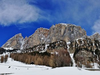 Low angle view of snowcapped mountains against blue sky