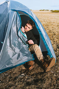 Full length of a smiling young man lying on field