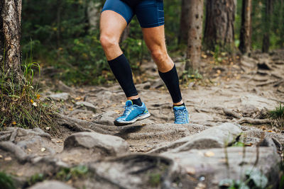 Low section of woman walking in forest