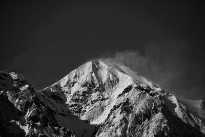 Low angle view of snowcapped mountains against sky