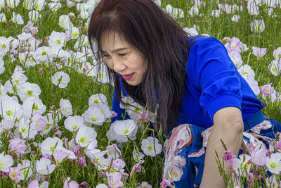 Midsection of woman with pink flowering plants