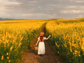 Rear view of woman walking on field