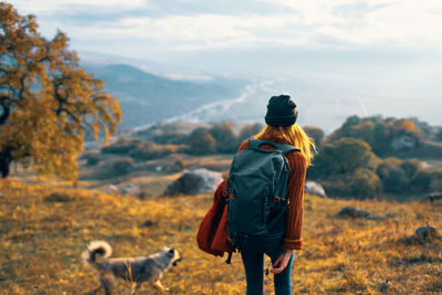 Rear view of man standing on land against sky