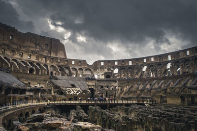 Low angle view of old ruins against cloudy sky