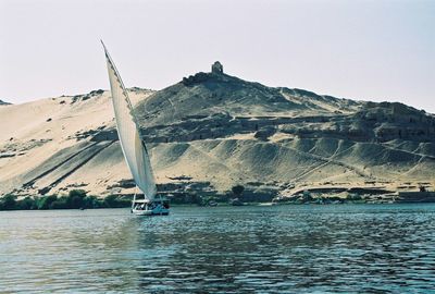 Sailboat in sea against clear sky