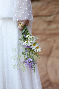 Midsection of woman holding a bridal bouquet