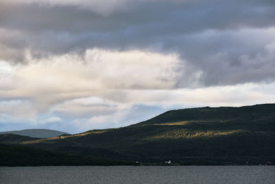 Scenic view of sea and mountains against sky