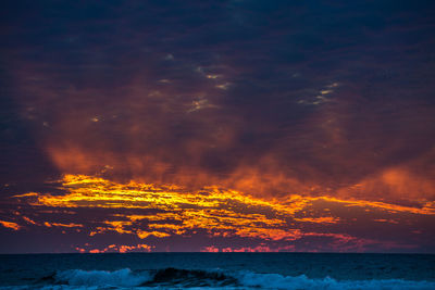 Scenic view of dramatic sky over sea during sunset