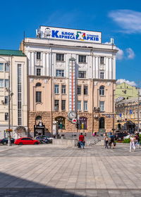 People on street against buildings in city