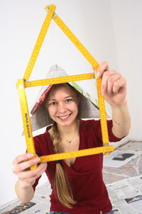 Portrait of smiling young woman holding yellow umbrella