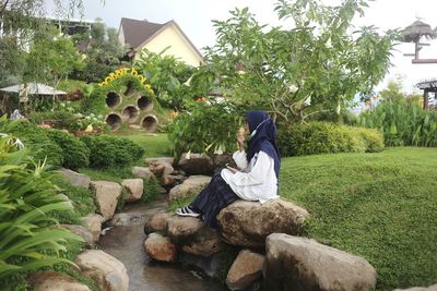 Rear view of man sitting on plants