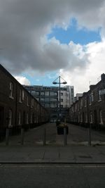 Silhouette buildings in city against cloudy sky