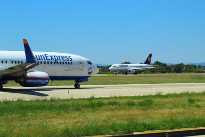 Airplane on airport runway against sky