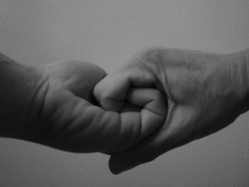 Close-up of father holding baby hand