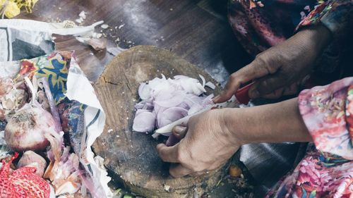 Close-up high angle view of hands chopping onion