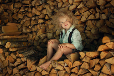 Portrait of boy sitting on logs