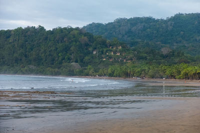 Scenic view of beach and mountains against sky