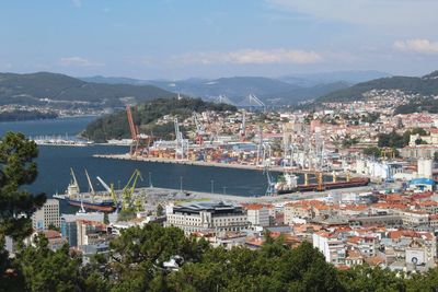 Aerial view of city by sea against sky