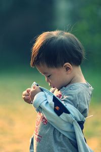 Side view of baby boy standing on field