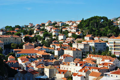 Aerial view of townscape against blue sky