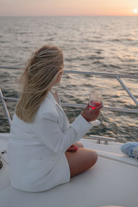 Side view of woman using mobile phone at beach