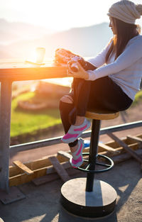 Side view of woman sitting outdoors