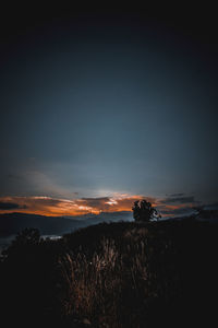 Scenic view of silhouette field against sky during sunset