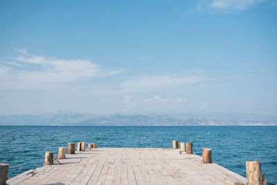 Wooden pier over sea against sky