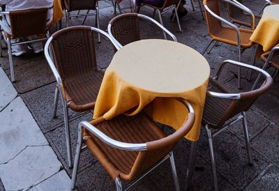 High angle view of empty chairs and table at sidewalk cafe